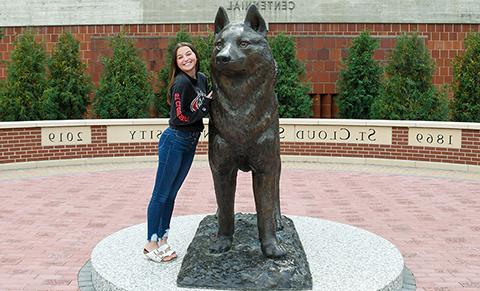 An SCSU student stands in Husky Plaza