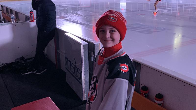 Kid standing by hockey ice